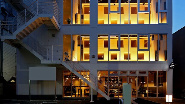 A modern building with a staircase, large windows, and a sign indicating a restaurant or bar. - UNPLAN Kagurazaka - Hostel (Tokyo)