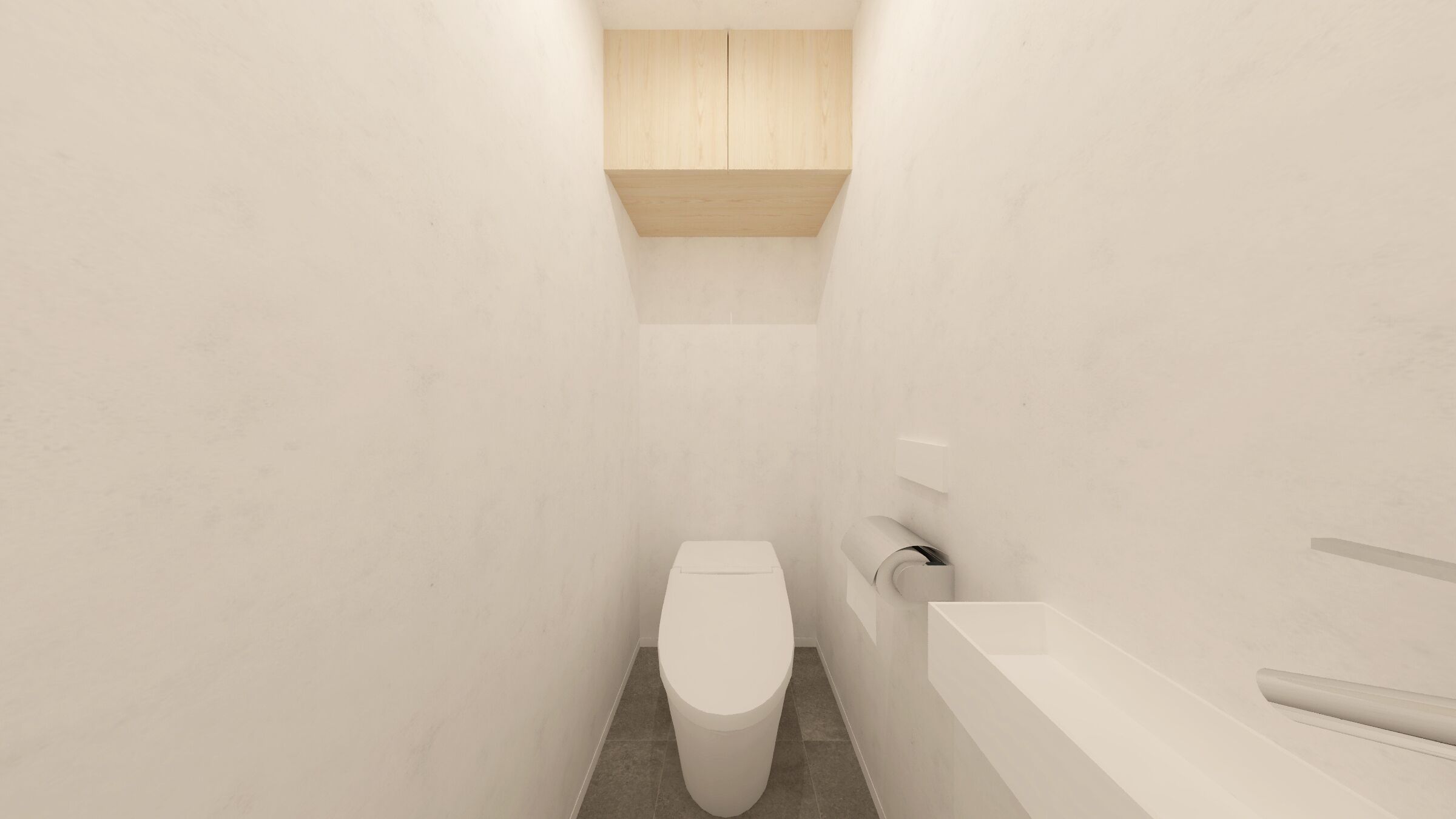 Une petite salle de bain aux murs blancs, équipée de toilettes et d’un lavabo blanc.