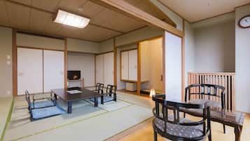 A traditional Japanese-style room with tatami flooring, a low table, and chairs.