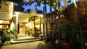 A building with a sign reading "Warisan Resort" at night.