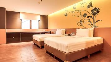 A hotel room with two beds, a desk, and a large mirror.