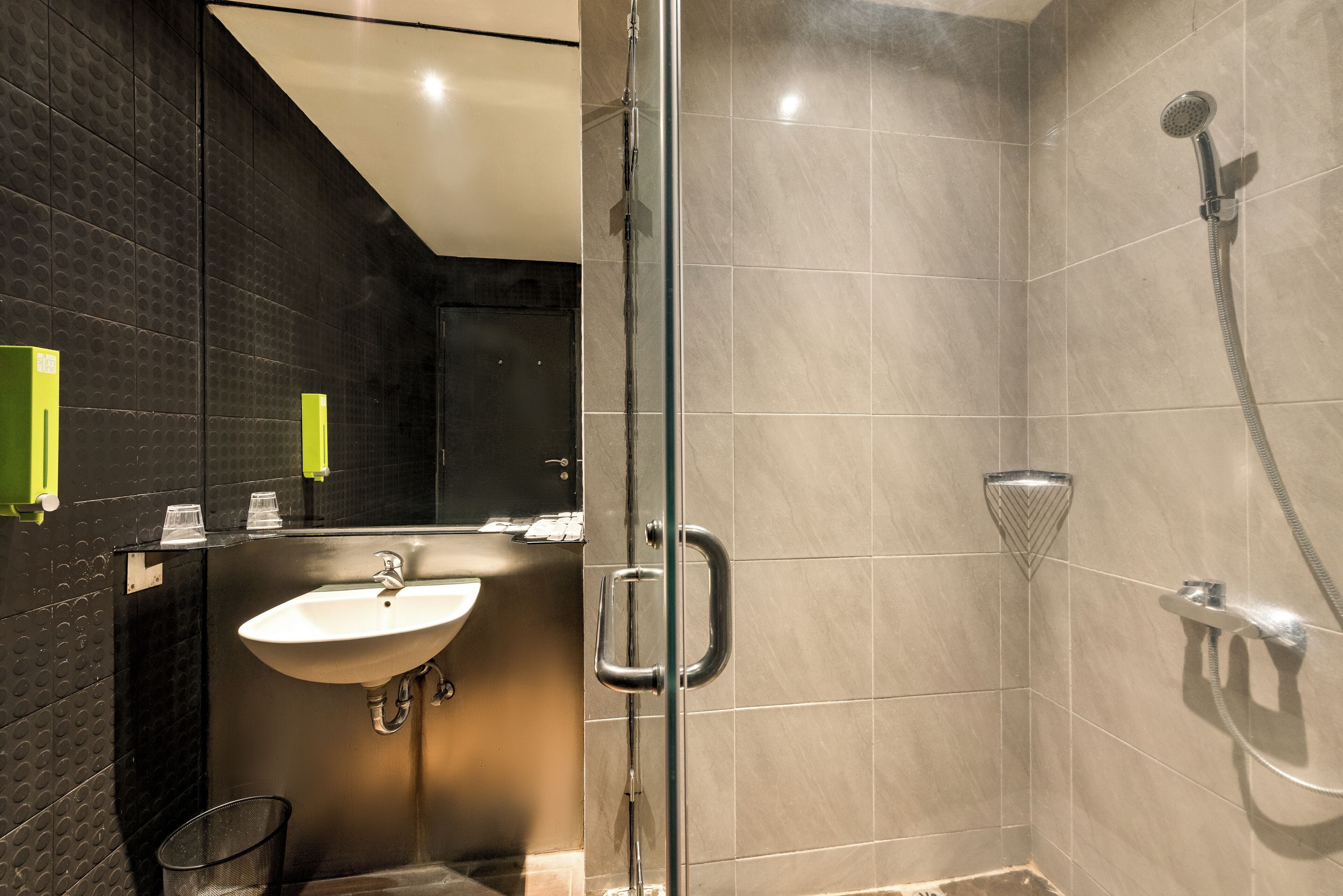 A modern bathroom with a glass-enclosed shower, a sink, and a mirror.