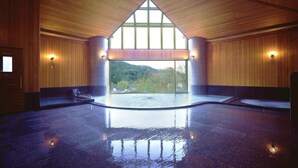A spacious indoor area with a high ceiling, large windows, and a central reflective floor.