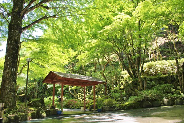 A tranquil garden with a wooden gazebo, a pond, and lush greenery. - Sora Togetsusou Kinryu (Izu)