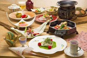 A variety of dishes on a wooden table, including a bowl of soup, a plate of sashimi, and a dish with vegetables and meat. - Sora Togetsusou Kinryu (Izu)