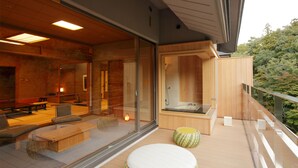 A modern spa area with a glass-enclosed room, wooden deck, and a view of the surrounding forest.