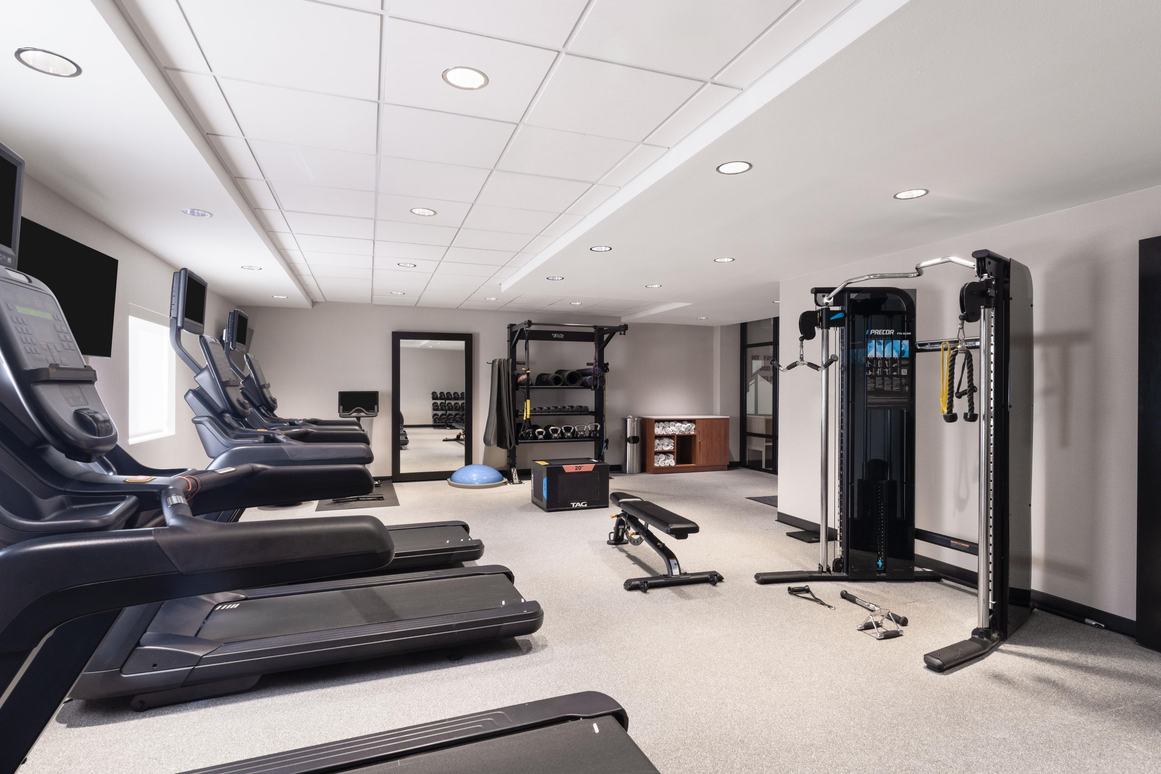 A gym with treadmills, a weight bench, and various exercise equipment.