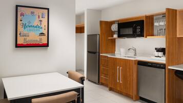 A modern kitchen with wooden cabinets, a stainless steel refrigerator, and a microwave.