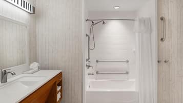 A modern bathroom with a double sink vanity, a bathtub, and a shower.