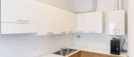 A modern kitchen with white cabinets, a gas stove, and a built-in dishwasher.