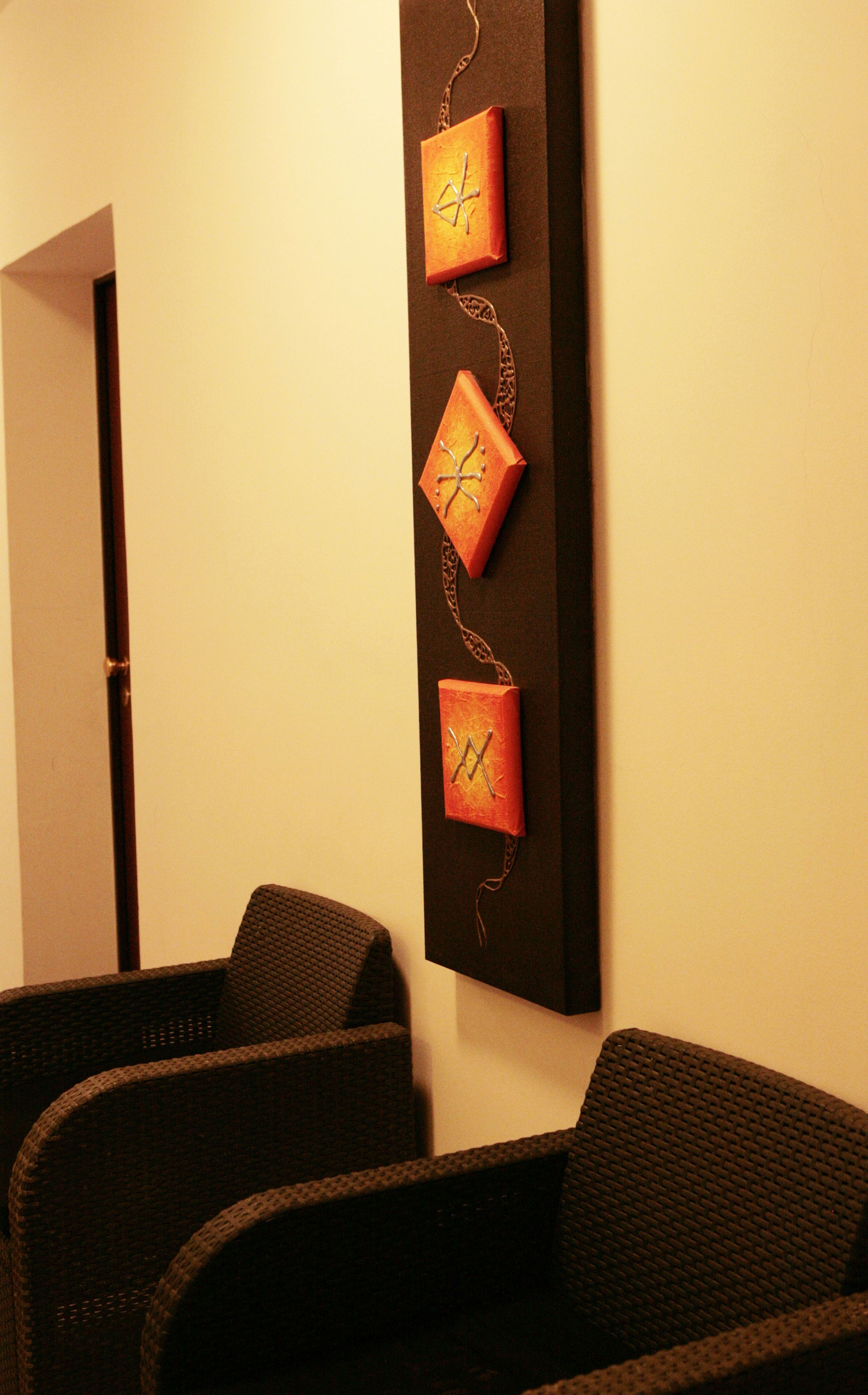 A reception area with a wall-mounted clock and two wicker chairs.