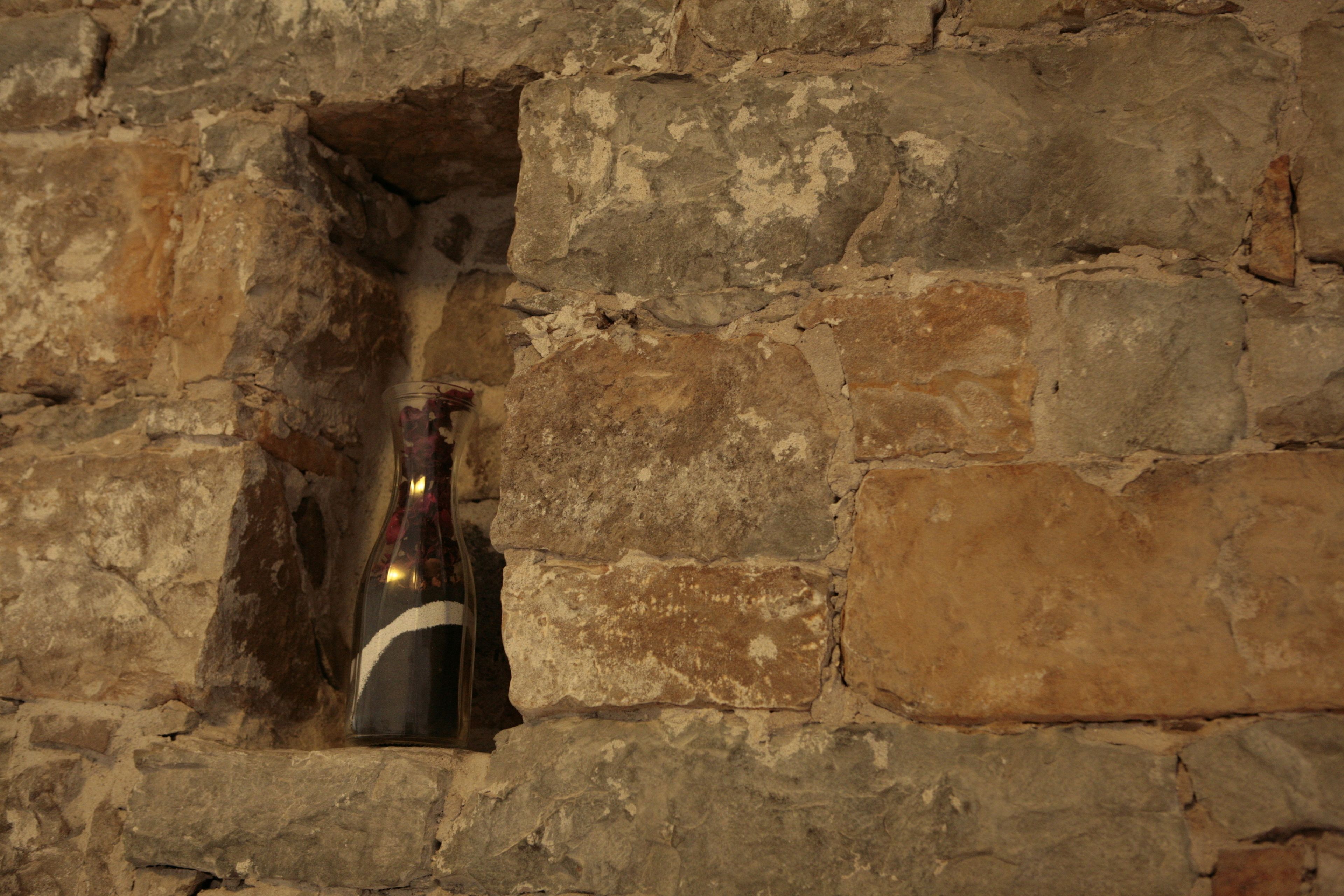 A bottle of wine in a stone wall niche.