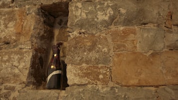 Una botella de vino en un hueco de pared de piedra.