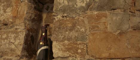 A bottle of wine in a stone wall niche.