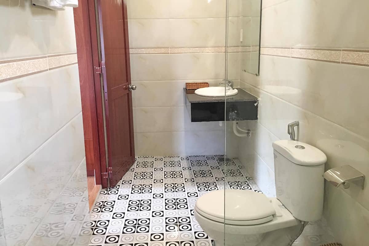 A bathroom with a toilet, sink, and shower area.