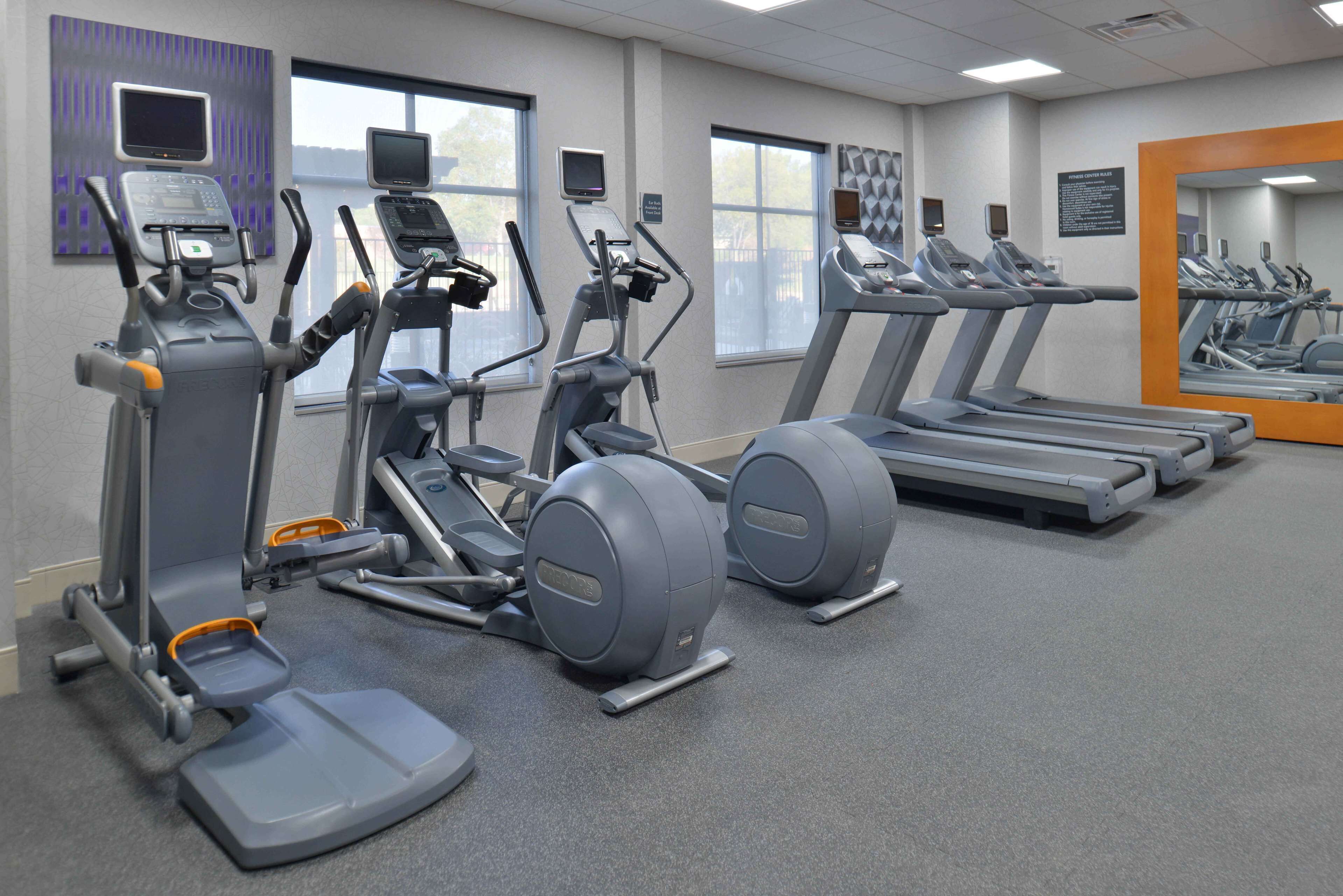 A gym with treadmills, elliptical machines, and stationary bikes.
