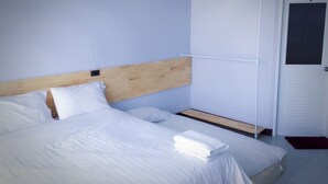 A neatly made bed with white linens, a wooden headboard, and a small wooden shelf beside it. - Sirin Loft Resident (Chiang Mai)