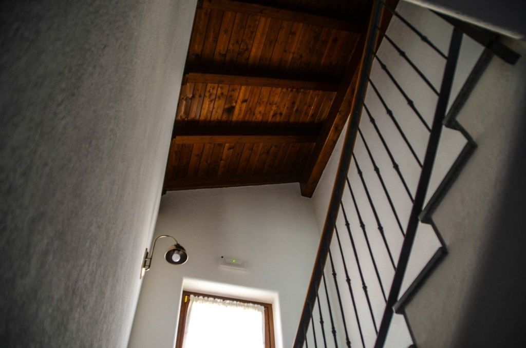 Una escalera con vigas de madera y barandilla de metal.