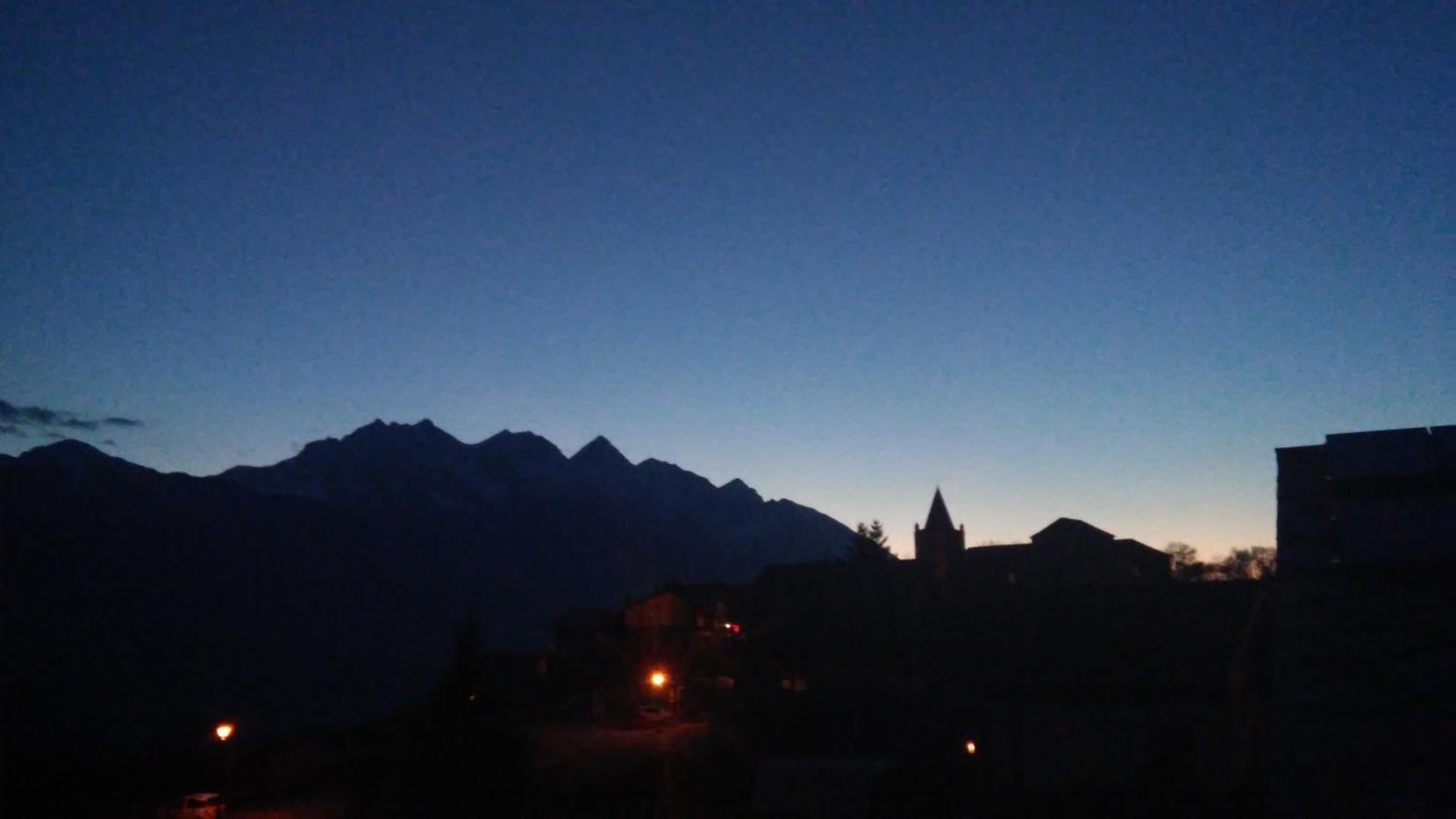 A mountain range silhouette against a twilight sky.