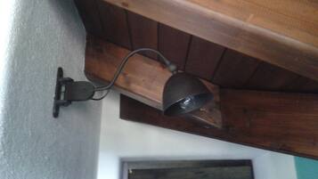 En väggmonterad lampa med en träbalk ovanför.