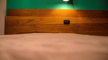 Un letto con testiera in legno e una lampada fissata al muro.