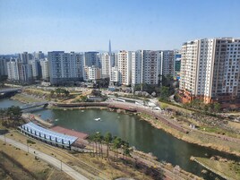 A high-rise residential area with a river, pedestrian paths, and a bridge.