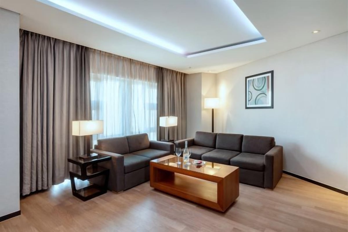 A modern living room with a sofa set, a coffee table, and two side tables with lamps.