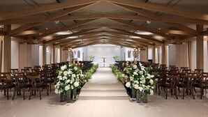 A spacious hall with wooden beams, rows of chairs, and floral arrangements. - Wirye Militopiahotel By Marine (Seongnam)