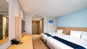 A hotel room with a large bed, a bedside table, a mirror, and a door leading to a hallway.