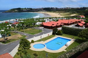室外游泳池，池畔遮阳伞，日光浴躺椅