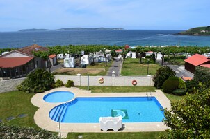 Una piscina al aire libre, sombrillas, tumbonas