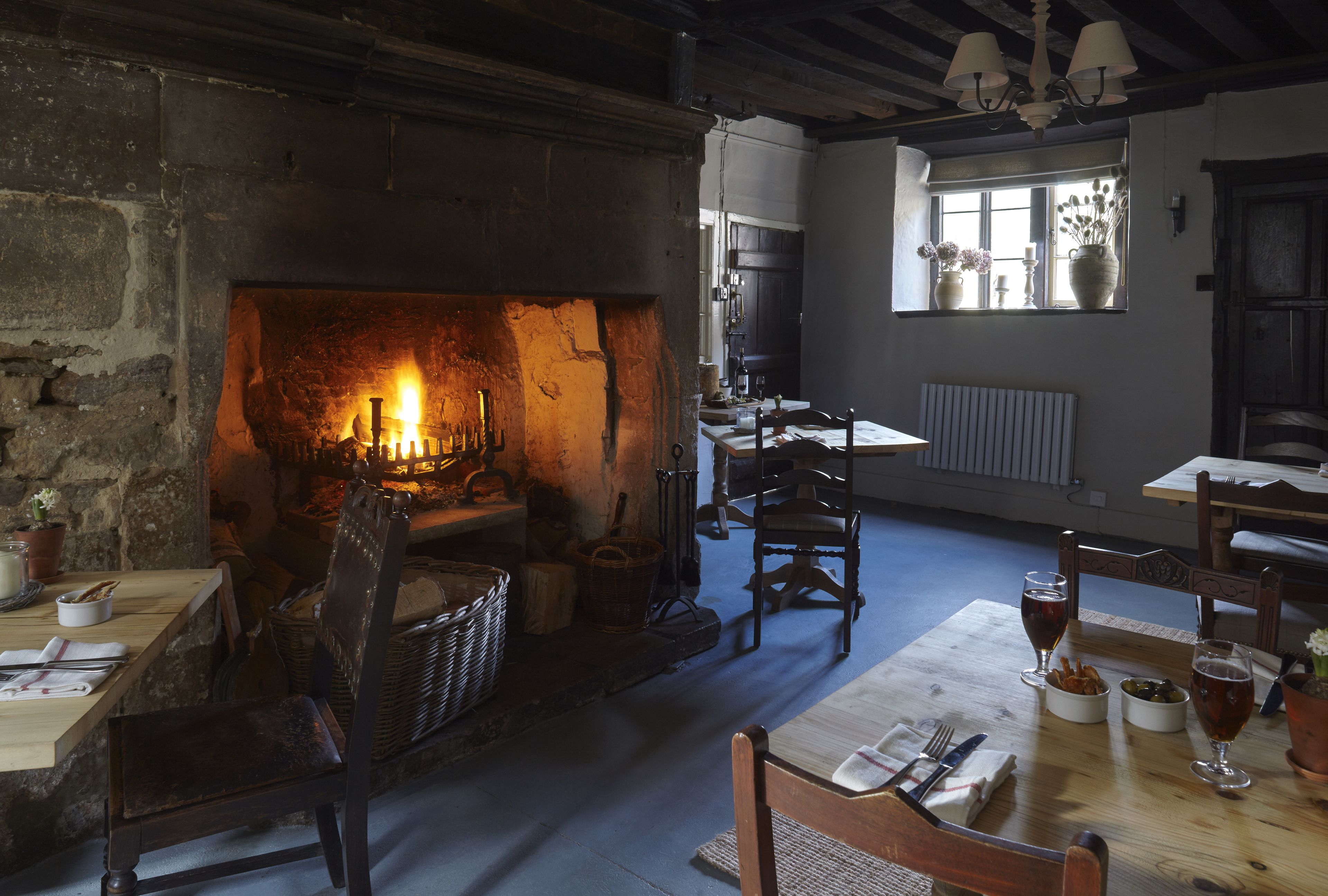 Une pièce chaleureuse avec une cheminée, des meubles en bois et une table mise pour le dîner.