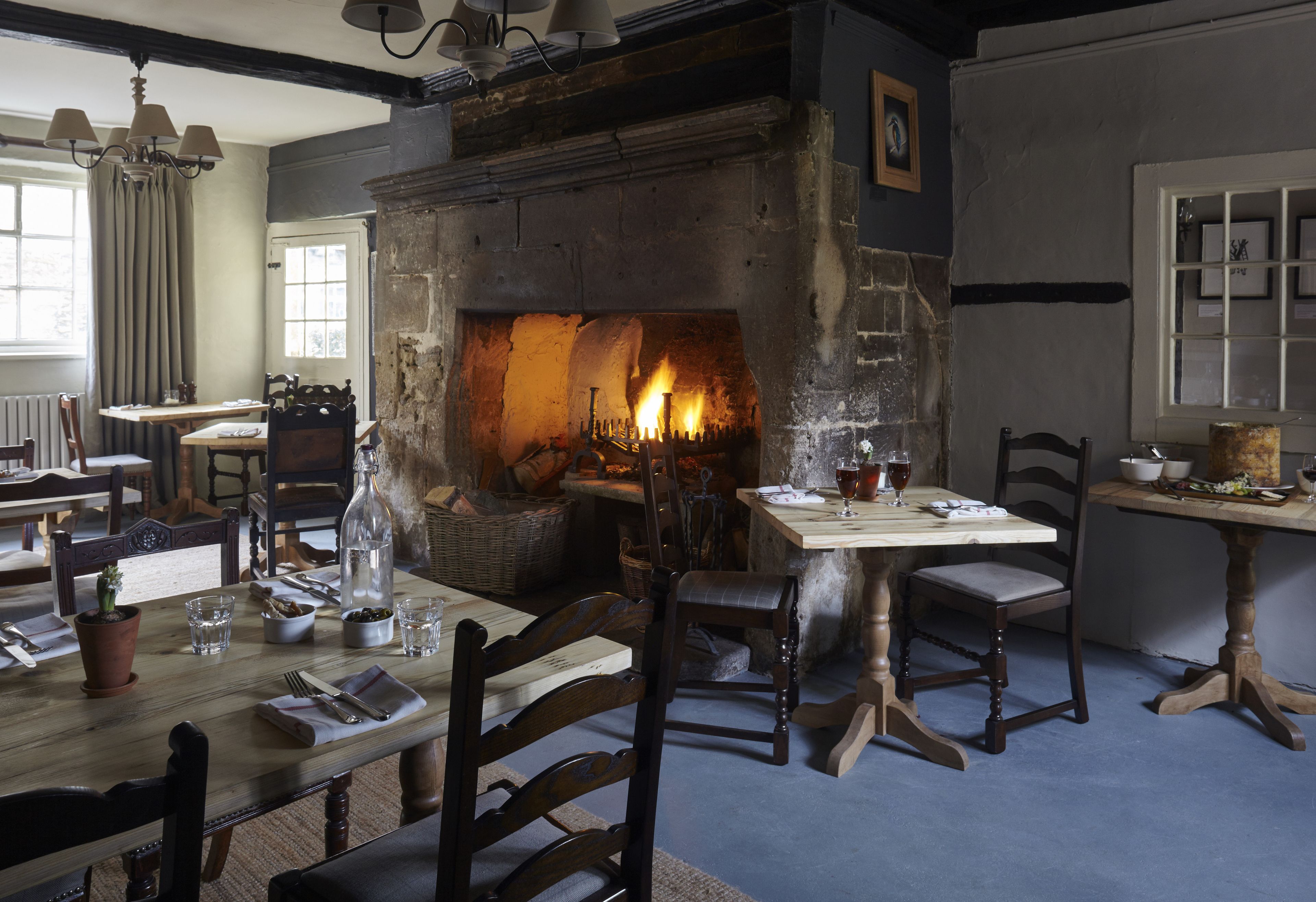 Un comedor con chimenea, muebles de madera y una mesa dispuesta para una comida.