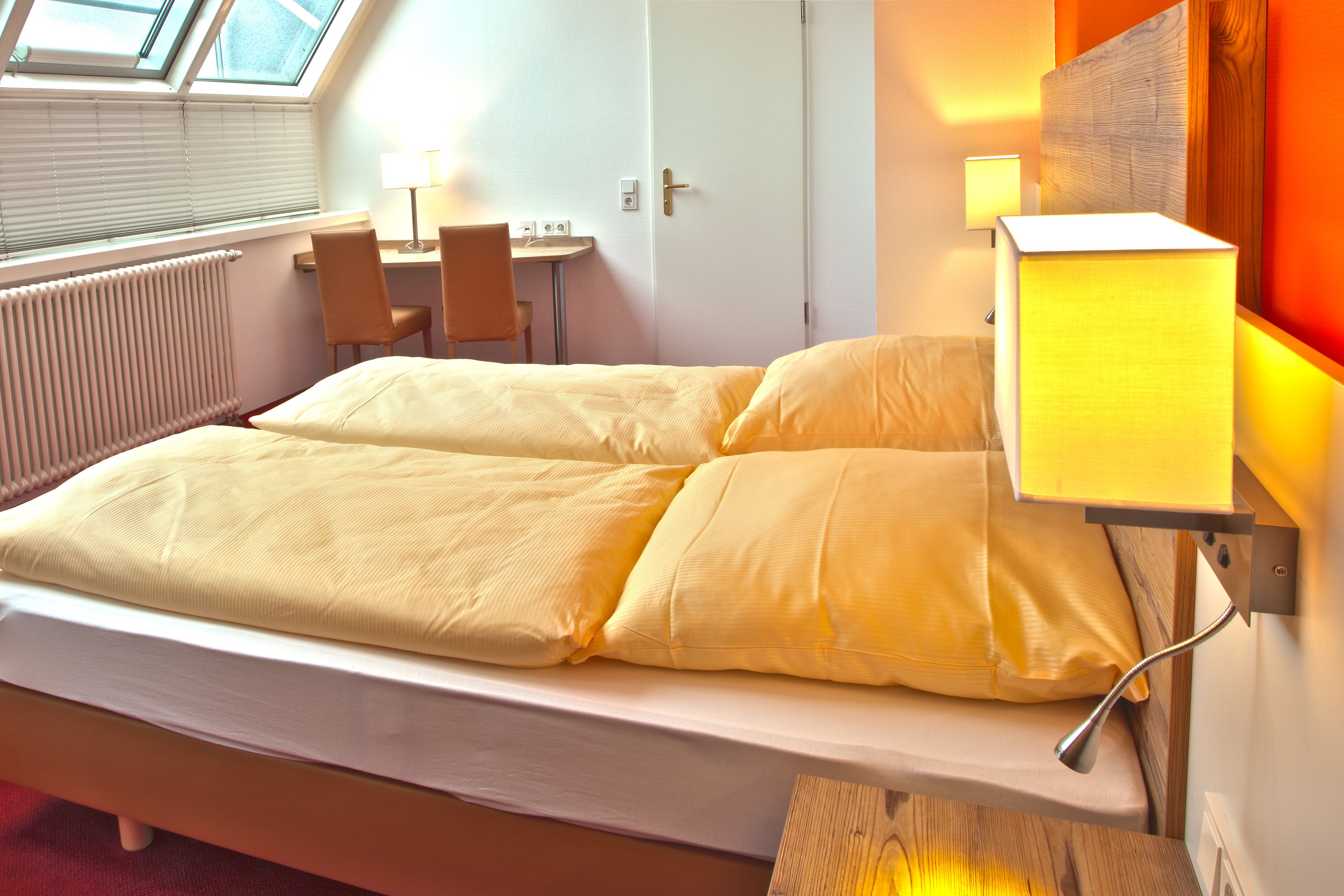 A hotel room with a bed, a desk, and a chair.
