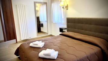 Relax in a spacious room with a large bed, featuring a comfortable headboard and ample storage.