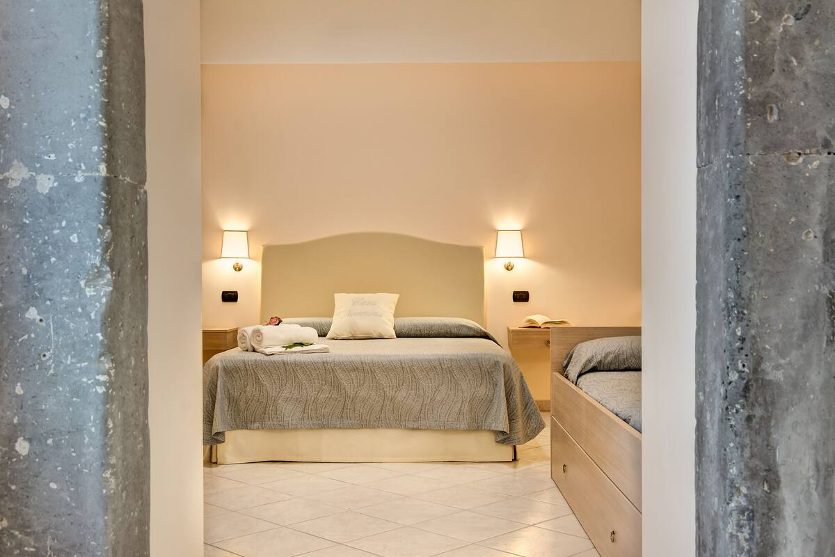 A bedroom with a bed, bedside tables, and a nightstand.