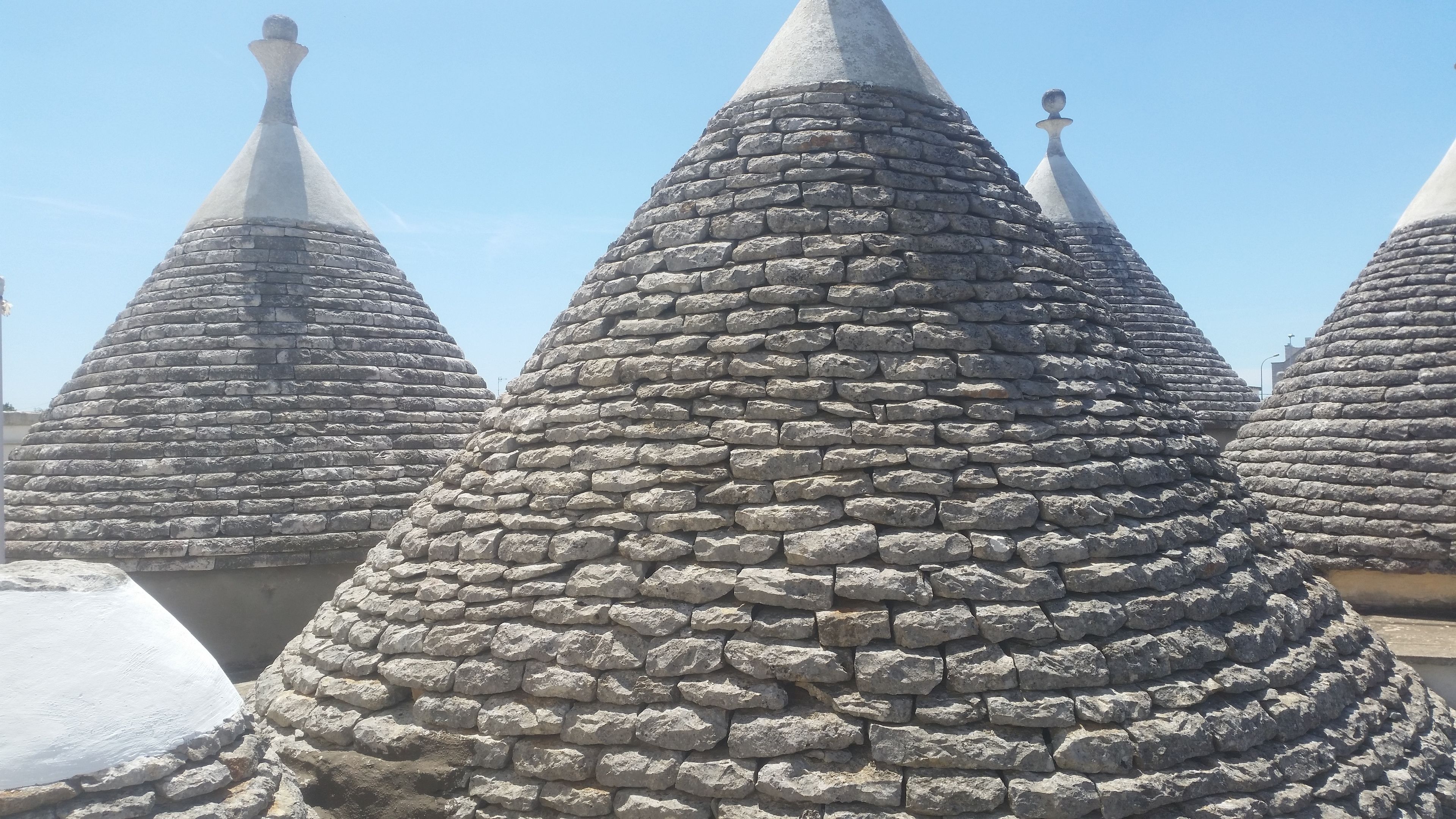 Una hilera de estructuras cónicas de piedra con un estilo arquitectónico uniforme.