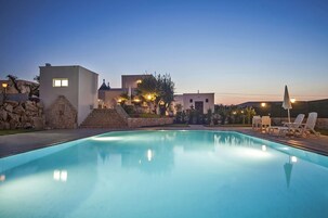 Una piscina al aire libre de temporada, sombrillas