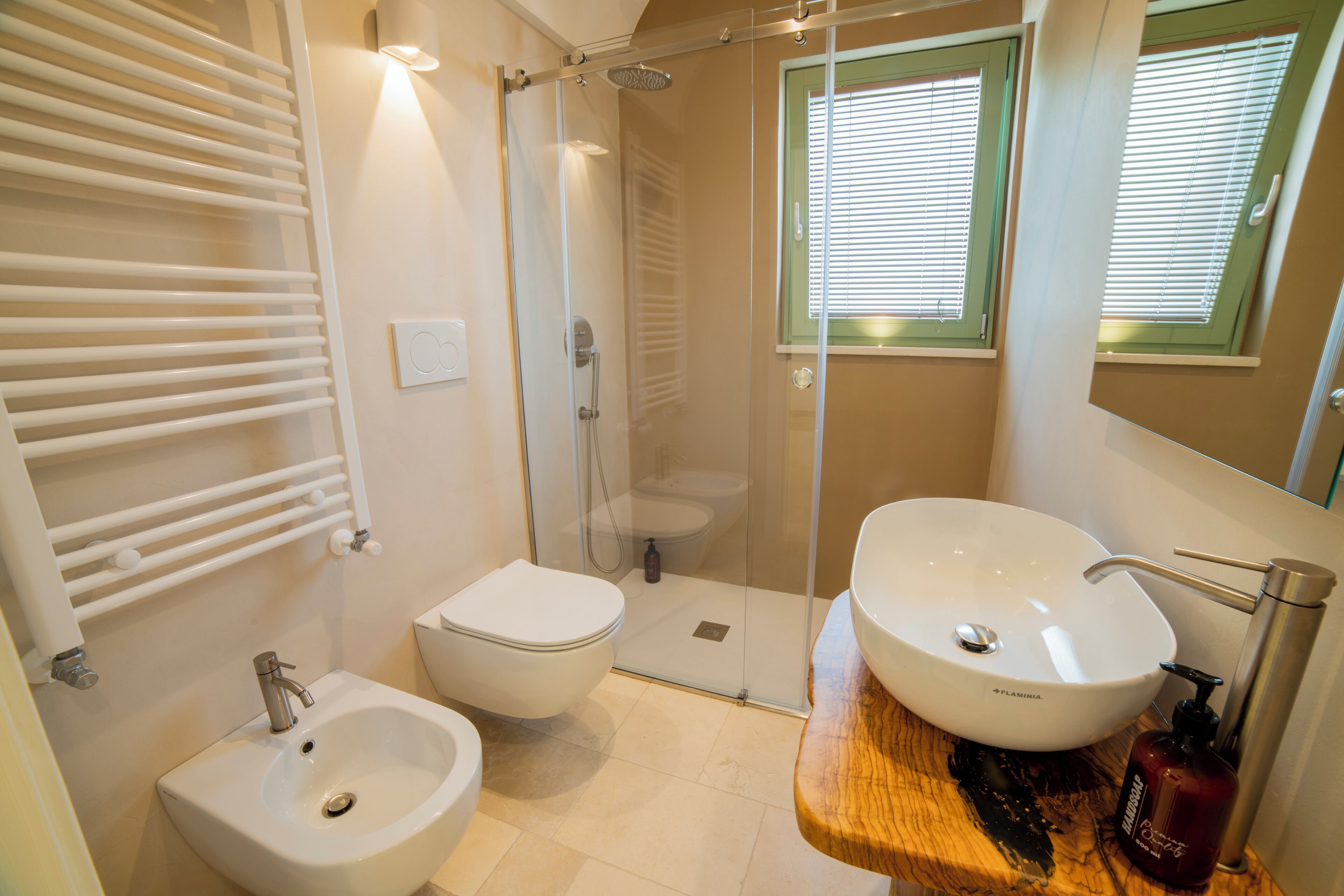 Ein Badezimmer mit einer Duschkabine, einem weißen Waschbecken und einer Toilette.