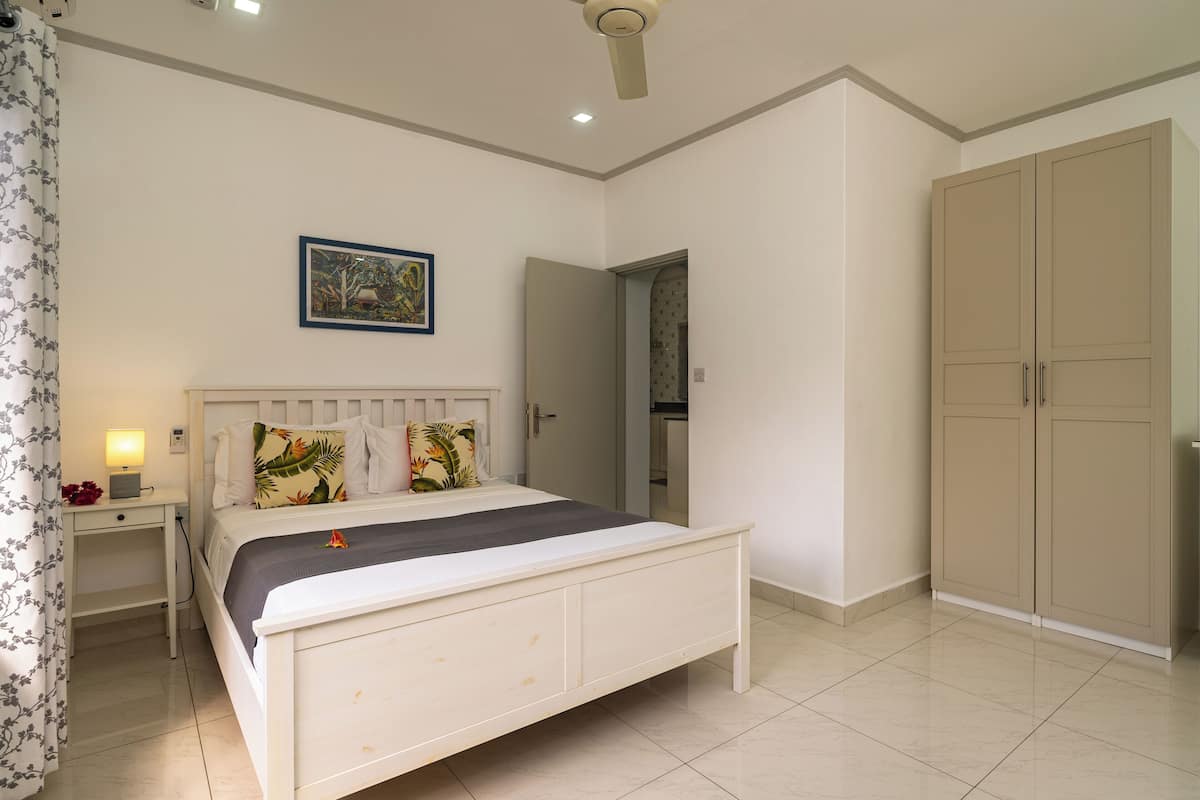 A bedroom with a bed, nightstand, and wardrobe.
