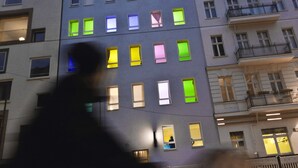 Un edificio de varios pisos con ventanas y balcones iluminados.