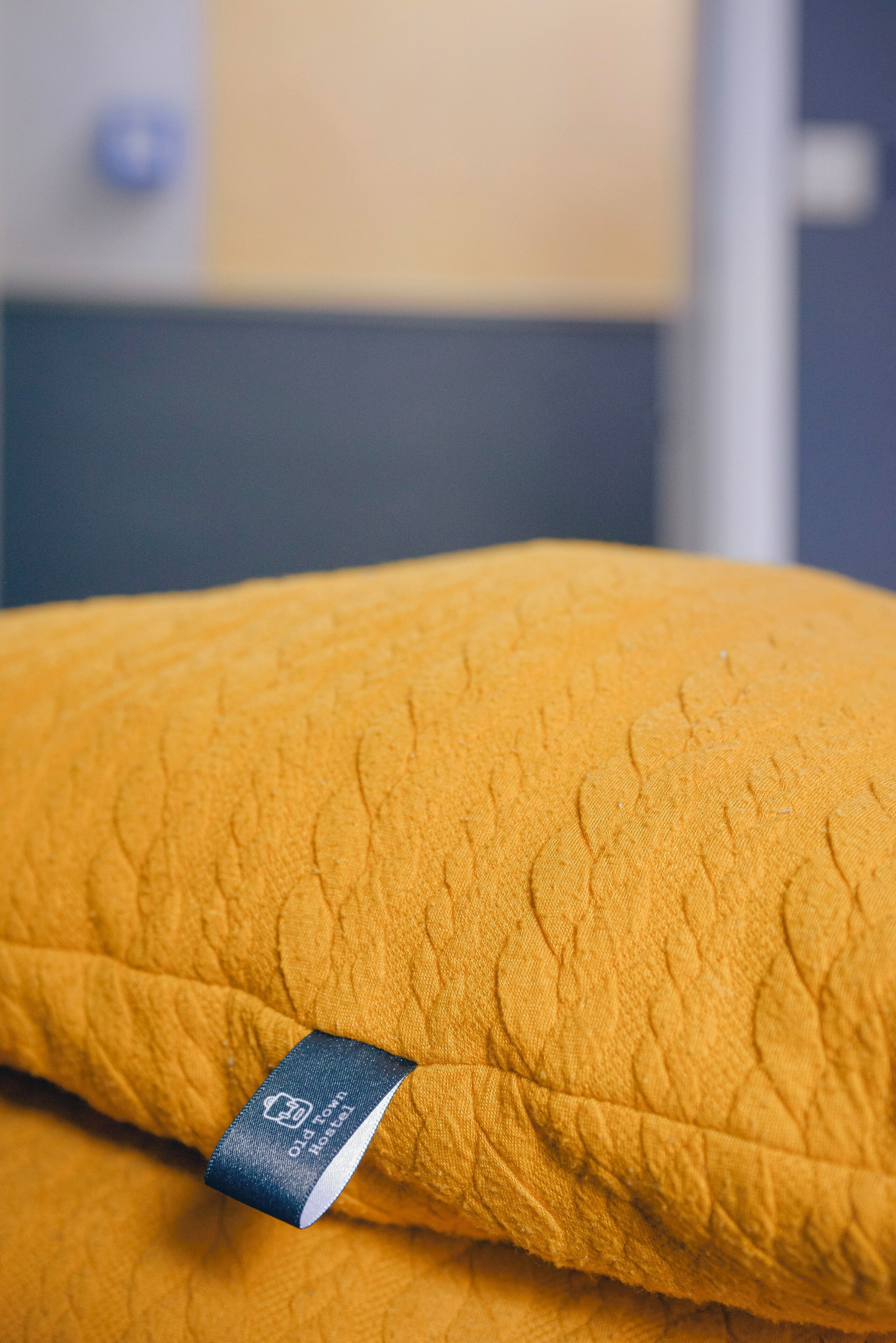A close-up of a yellow textured fabric with a tag reading "Old Town Mattress."