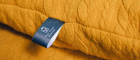 A close-up of a yellow textured fabric with a tag reading "Old Town Mattress."