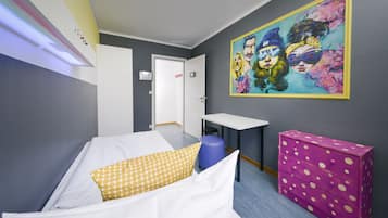 A room with a bed, a desk, a chair, a dresser, and a wall with a colorful painting.