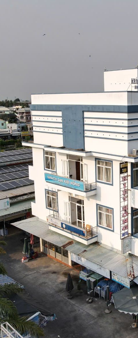 A multi-story building with a sign indicating 'KHACH SAN KIEU HONG' on the facade.