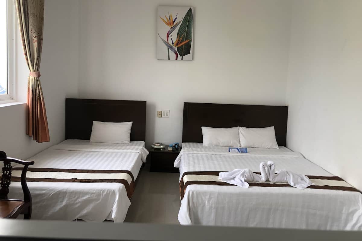 A hotel room with two beds, a nightstand, a chair, and a painting on the wall.