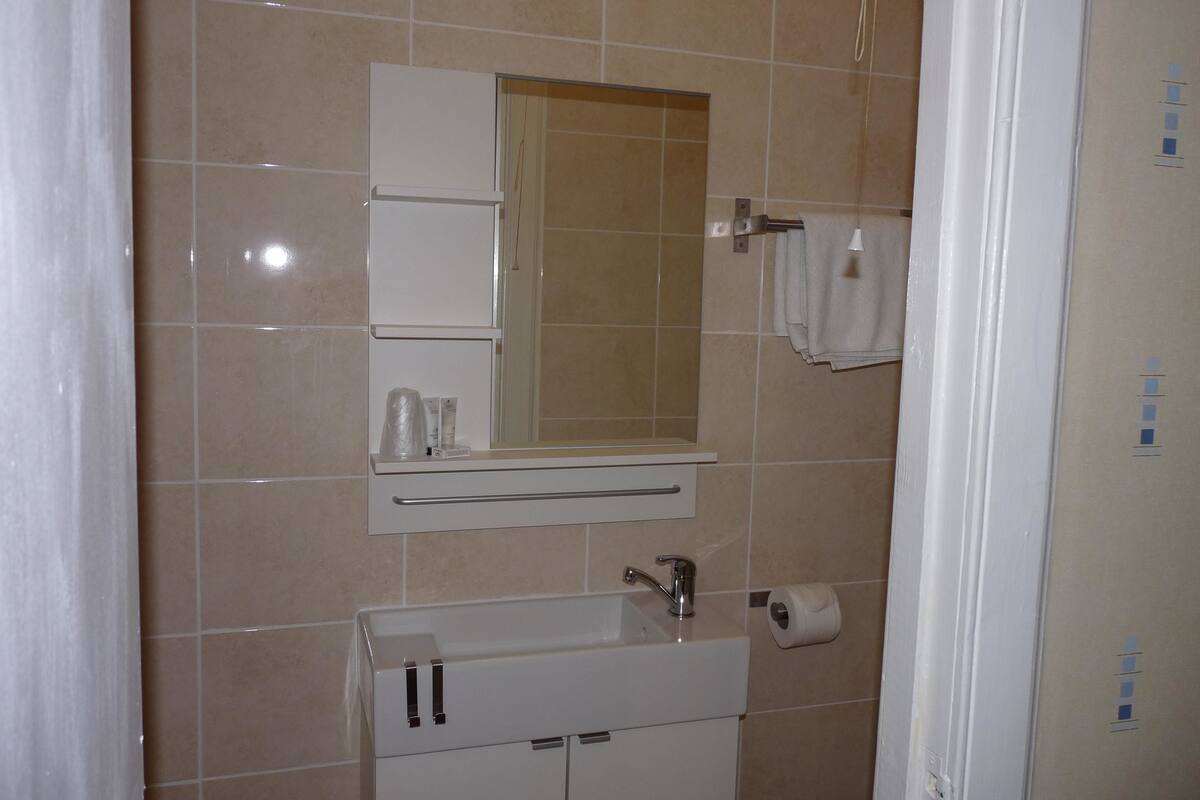 A bathroom with a sink, mirror, and towel rack.