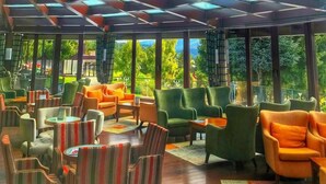A spacious indoor area with multiple seating arrangements, large windows, and a high ceiling with skylights. - Abant Palace Hotel (Mudurnu)