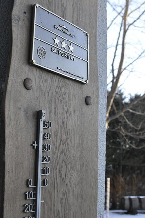 A wooden wall with a metal plaque indicating a "Superior" rating and a metal scale with numbers from 0 to 50. - Rennsteighotel Herrnberger Hof (Neuhaus am Rennweg)