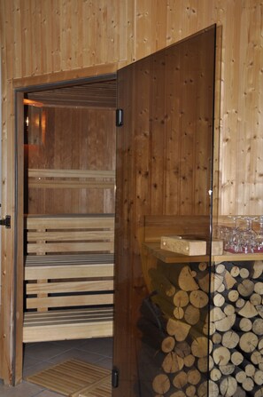 A wooden sauna room with benches and a glass door. - Rennsteighotel Herrnberger Hof (Neuhaus am Rennweg)